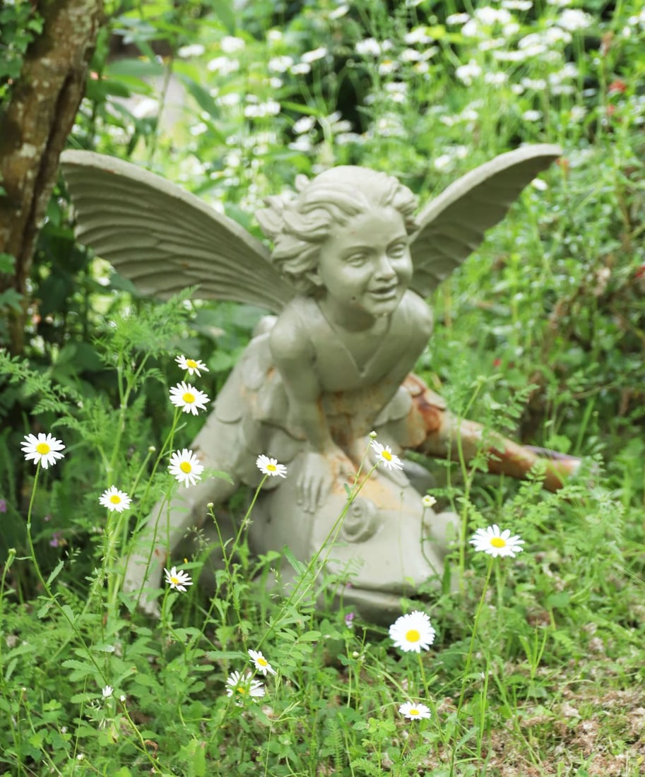 CAST IRON FIGURAL GARDEN SCULPTURE: Modelled as a winged fairy seated upon a frog. Retaining traces of painted finish.