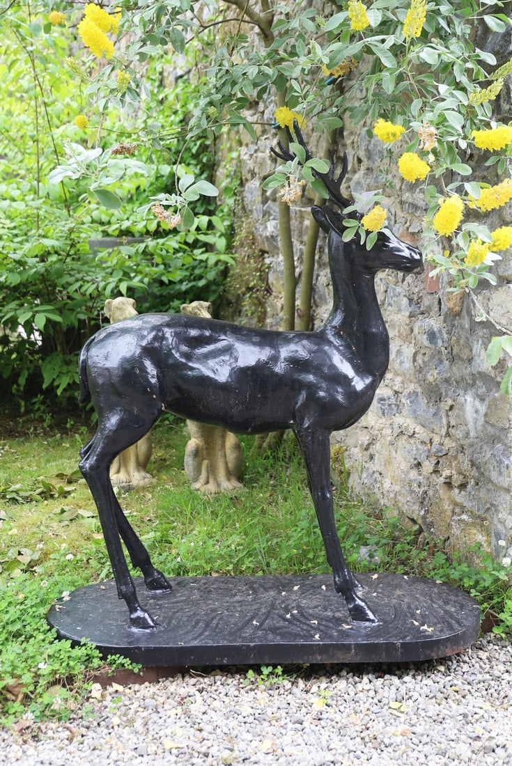 LARGE CAST IRON STAG GARDEN SCULPTURE: Large cast iron model of a standing stag with branching antlers, finished in black paint and raised on an integral oval base.