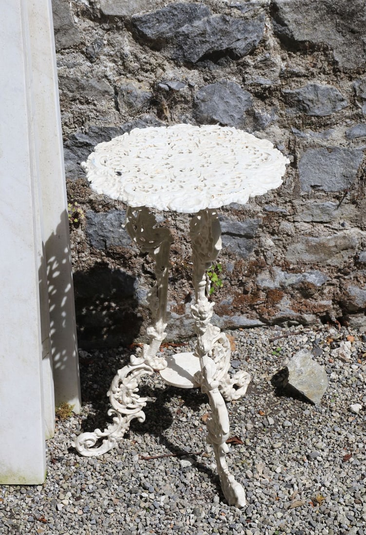CAST IRON OCCASIONAL TABLE: Decorative cast iron garden table with pierced circular top raised on elaborate rococo-inspired supports.