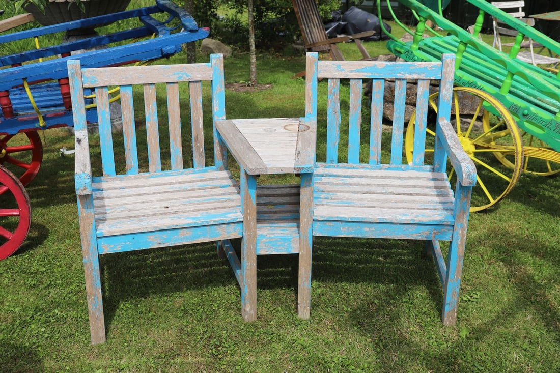 HARDWOOD COMPANION SEAT: Weathered hardwood companion seat, the slatted armchairs joined by a central table with parasol aperture.