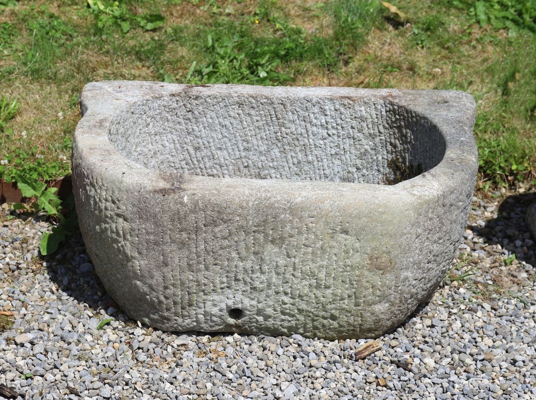 19TH-CENTURY GRANITE STONE TROUGH: Large carved granite trough of rectangular form with rounded ends and integral lug handles, the deep hollowed interior with weathered surface and natural patination throughout.