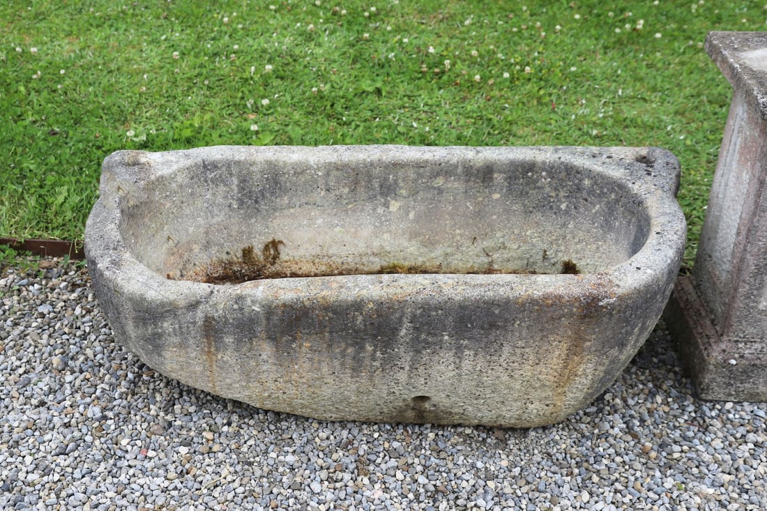 19TH-CENTURY GRANITE STONE TROUGH: Large carved granite trough of rectangular form with rounded ends and integral lug handles, the deep hollowed interior with weathered surface and natural patination throughout.