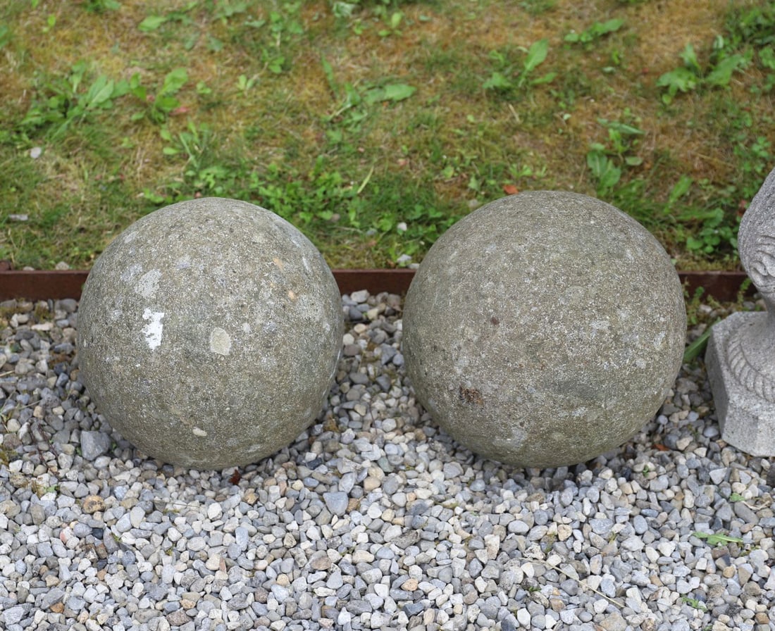 PAIR OF STONE GARDEN SPHERES: A pair of substantial weathered stone garden spheres, suitable as gate pier ornaments or landscape features.