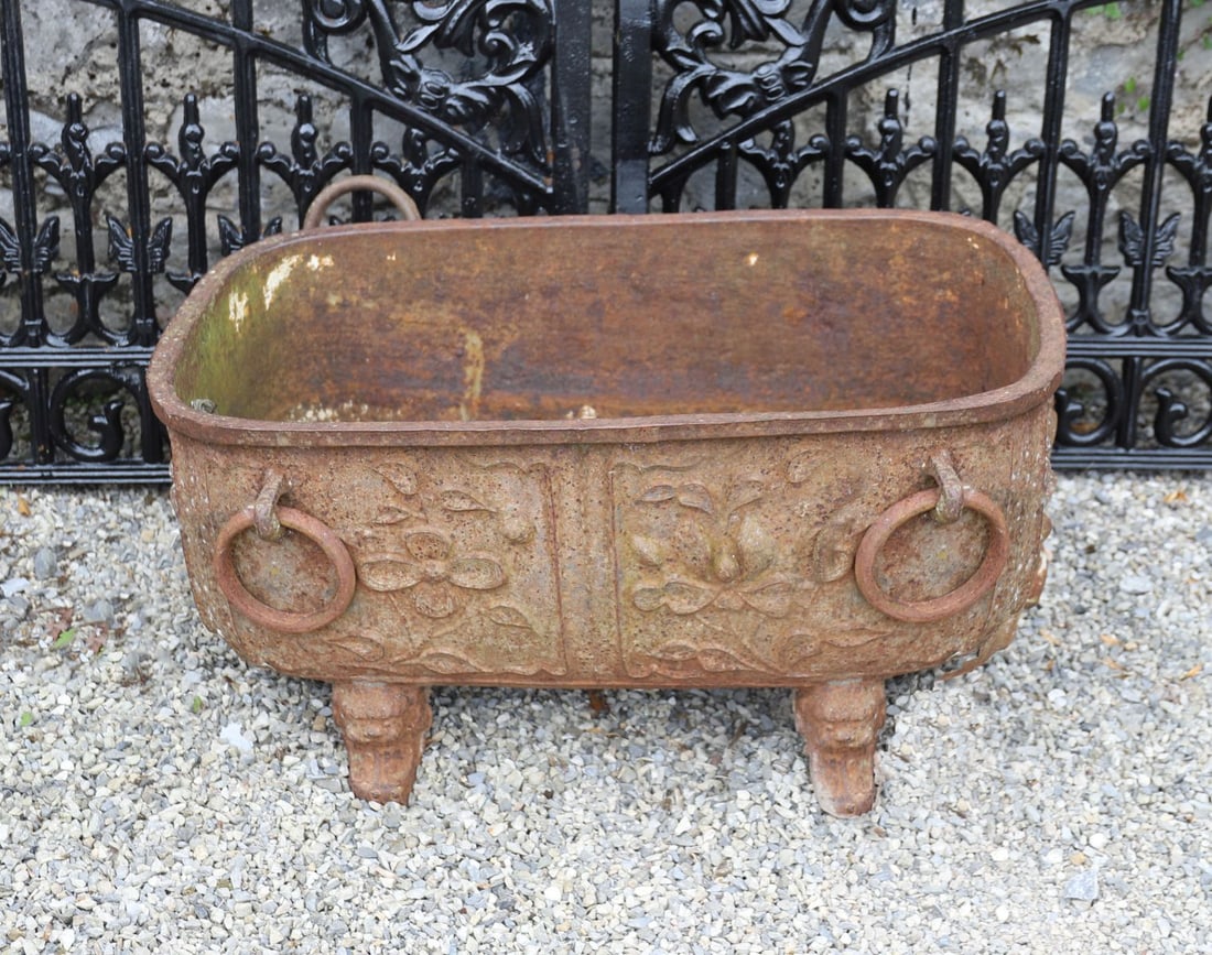 18TH-CENTURY CHINESE CAST IRON WATER TROUGH: of sarcophagus form with raised moulded decoration, furnished with robust ring handles, raised on foo mask scroll legs. Mark of Qianlong to the fore.