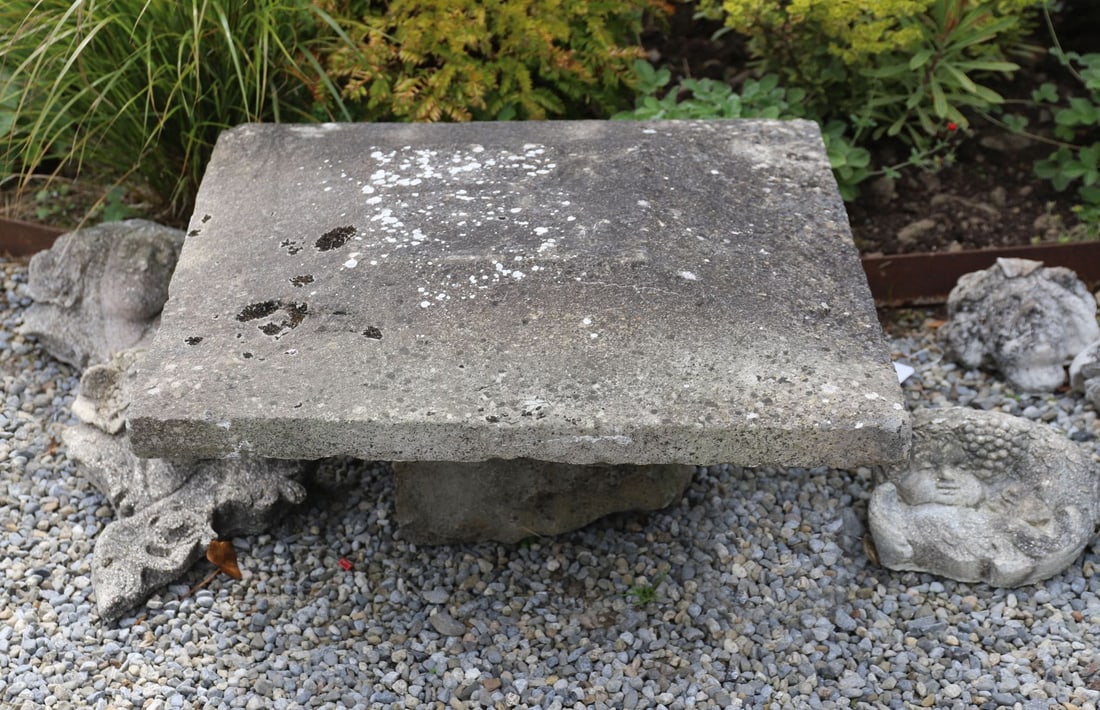 PAIR OF CUT STONE PIER CAPS: Pair of substantial cut stone pier caps with triangular arched upper surfaces, weathered finish and lichen growth.