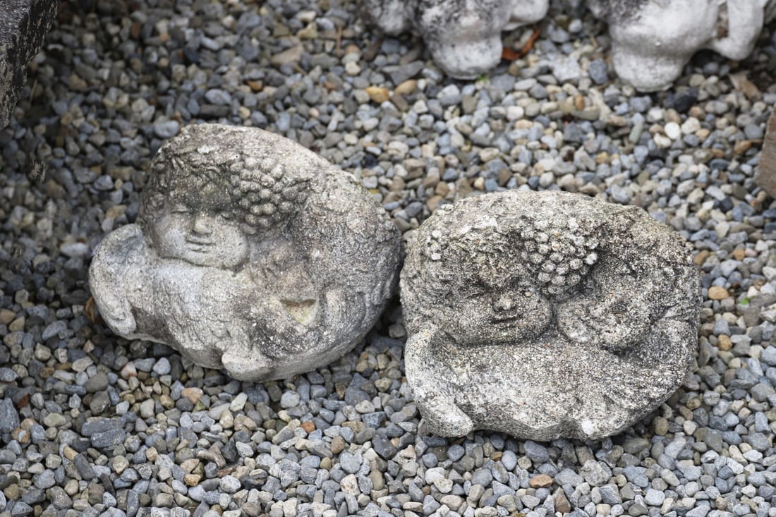 MOULDED GRANITE STONE GARDEN WALL POCKET: Decorative moulded granite wall pocket incorporating a winged cherub mask within scrolling acanthus decoration.