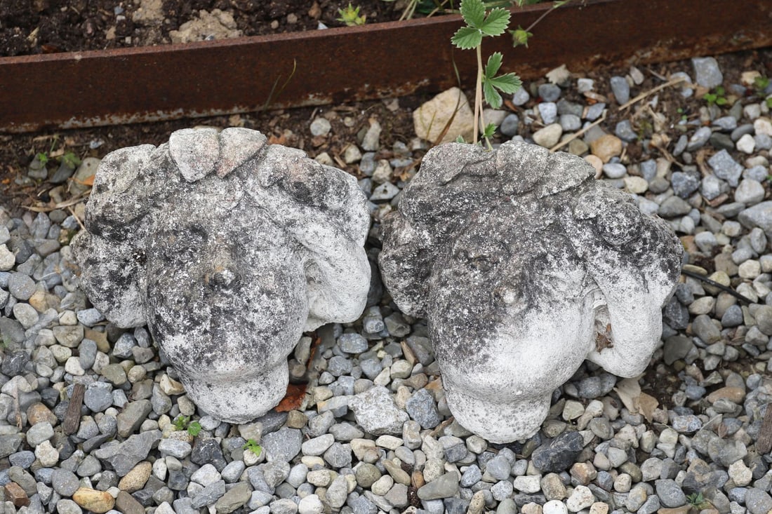 MOULDED GRANITE STONE GARDEN WALL POCKET: Decorative moulded granite wall pocket incorporating a cherub mask and scrolling foliate decoration.