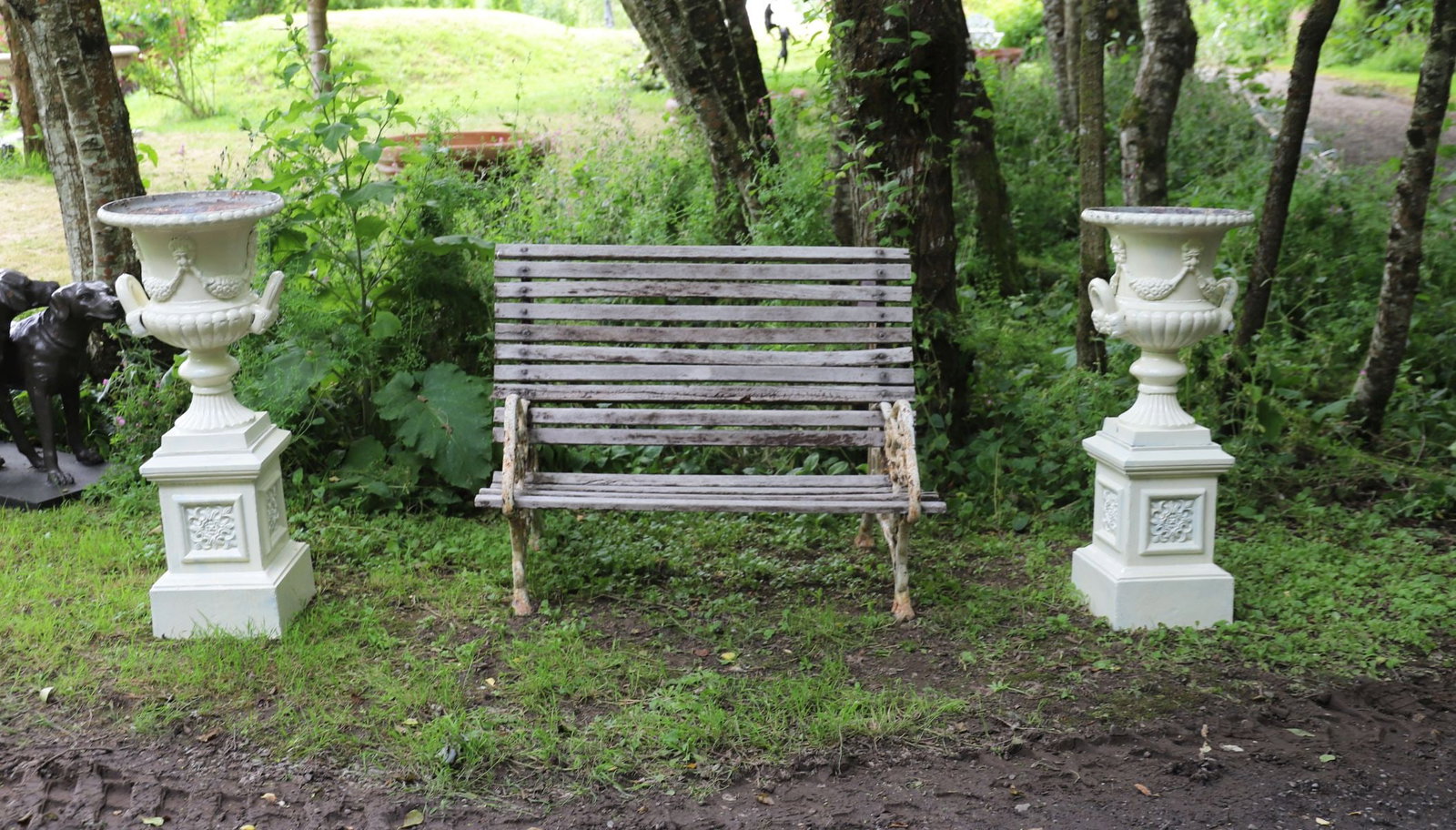PAIR OF CAST IRON PEDESTAL URNS: Pair of decorative cast iron pedestal urns of square form, each centred with a raised floral rosette panel and moulded borders, raised on stepped plinth base