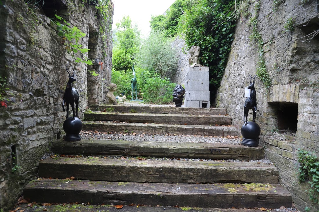 PAIR OF CAST IRON ANTELOPE FINIALS: Decorative cast iron antelope figures raised upon spherical plinth bases, suitable as gate or pier finials.