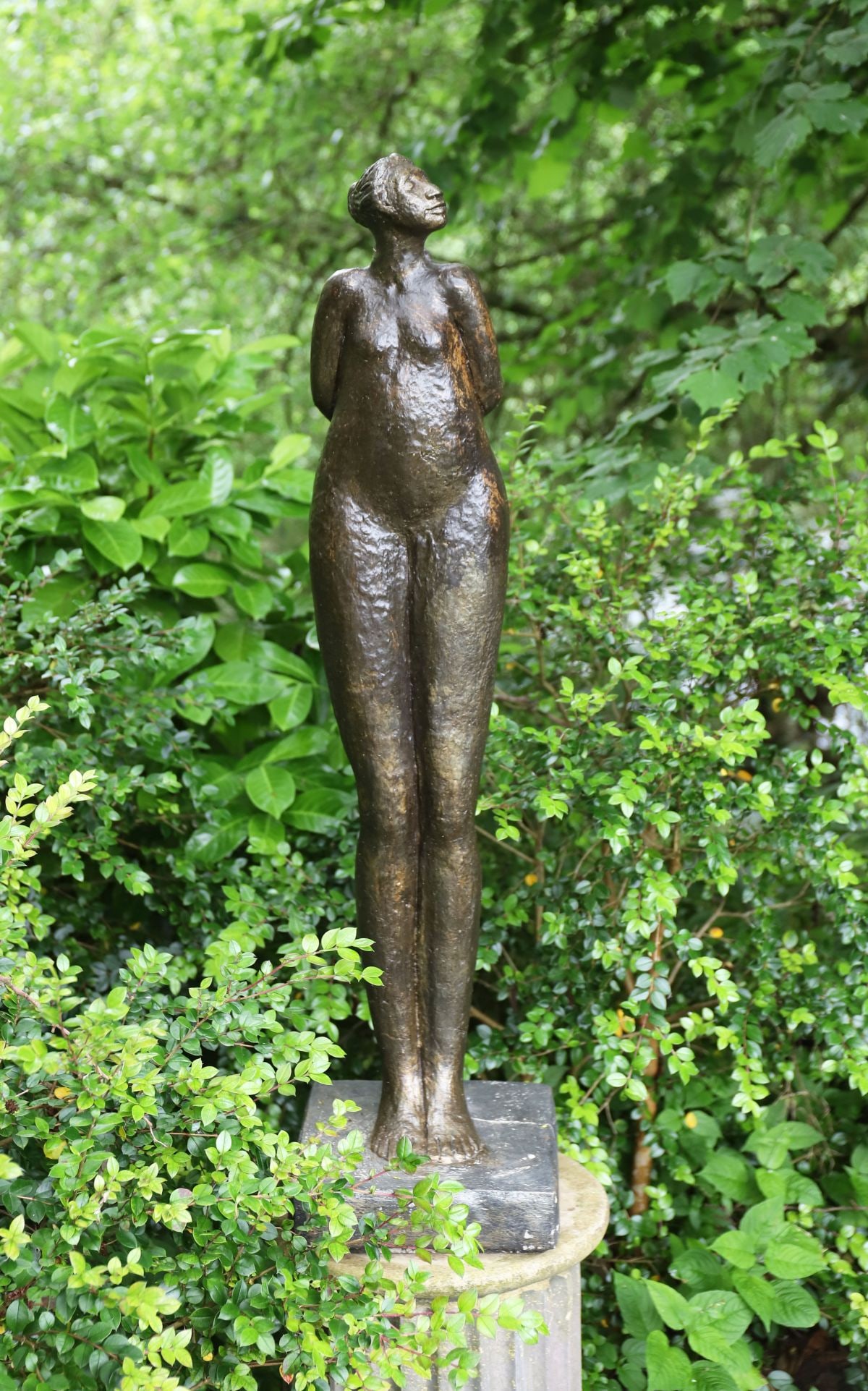 ABSTRACT MOULDED STONE FEMALE NUDE: ON SQUARE PLINTH A classically styled moulded stone sculpture of a female figure, raised on a square plinth base.