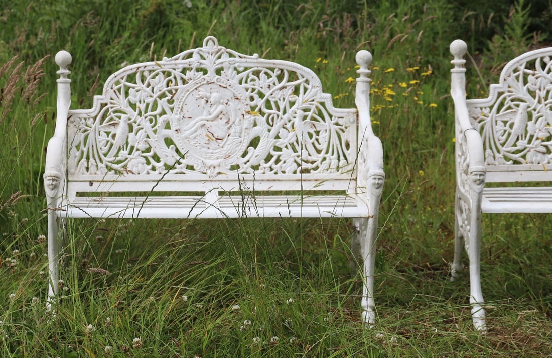 HEAVY CAST IRON CAMEO BACK GARDEN BENCH: with ornate leaf decorated back centred by an oval panel depicting a muse with bird, raised on scroll ends.