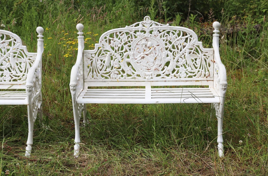 HEAVY CAST IRON CAMEO BACK GARDEN BENCH: with ornate leaf decorated back centred by an oval panel depicting a muse with bird, raised on scroll ends.