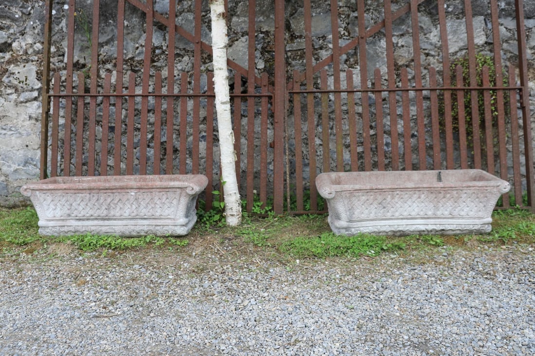 PAIR OF COMPOSITE STONE PLANTERS: The rectangular bodies cast with Celtic knotwork panels and moulded borders, raised on integral plinth bases.