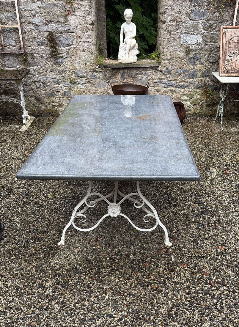 LARGE METAL AND SLATE GARDEN TABLE: large metal and slate garden table with rectangular slate top, the white-painted cast iron base with scrolling supports centred by a floral roundel.