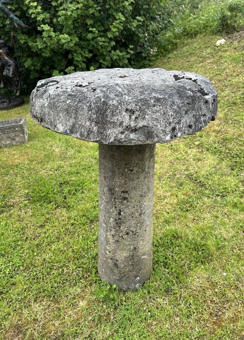 18TH-CENTURY STADDLE STONE: Granite staddle stone with cylindrical stem and weathered surface.