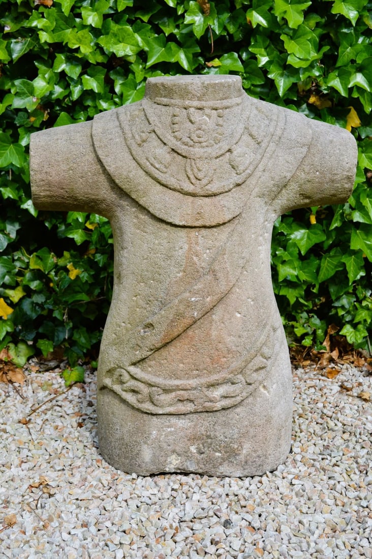 CARVED STONE CELTIC TORSO: A carved stone sculpture of a Celtic torso, stylised with abstracted features and symbolic detailing. Evocative of early Irish stone carving traditions.