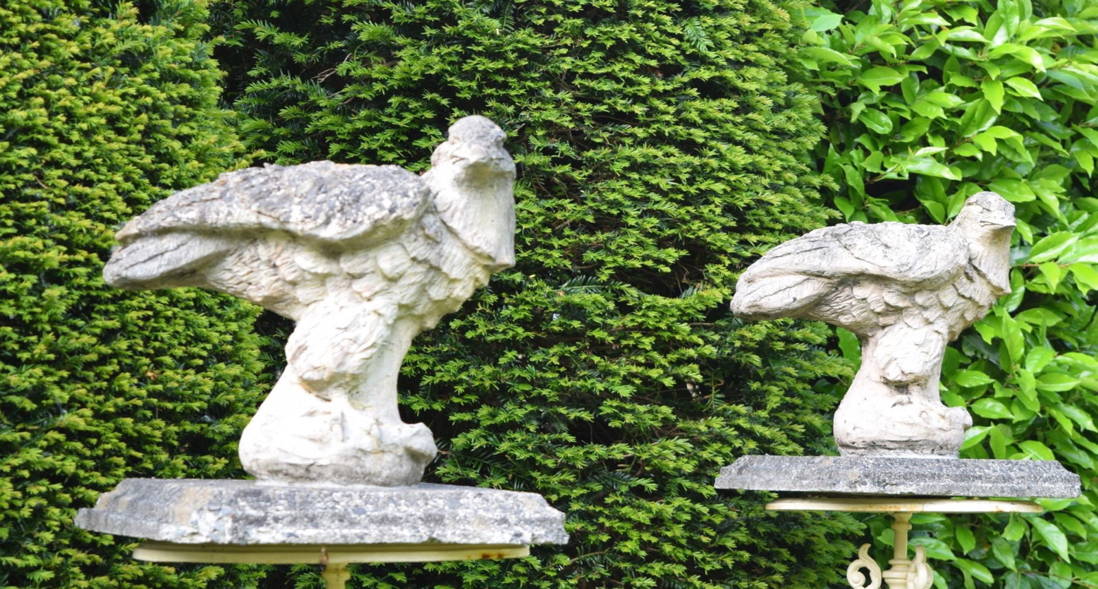 PAIR OF STONE PIER CAPS MODELLED ON EAGLES: A dramatic pair of carved stone pier caps, each surmounted by a sculpted eagle with wings partially spread. Designed to sit atop entrance piers.