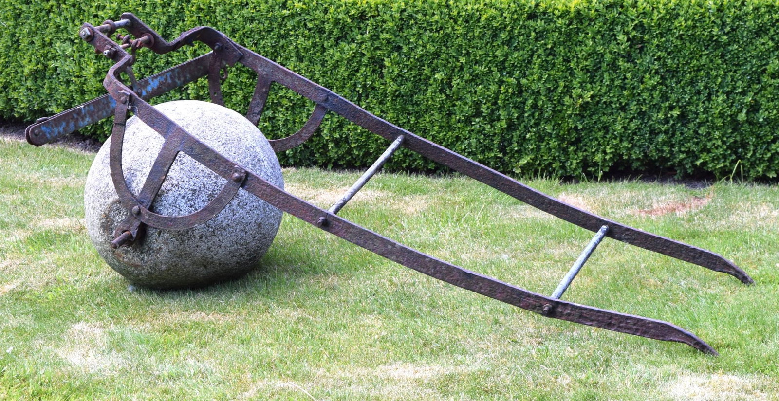 VICTORIAN GRANITE ROLLER WITH IRON HANDLE: A Victorian-era garden roller crafted from solid granite, fitted with a wrought iron pull handle. Robust and functional with age-related patina.