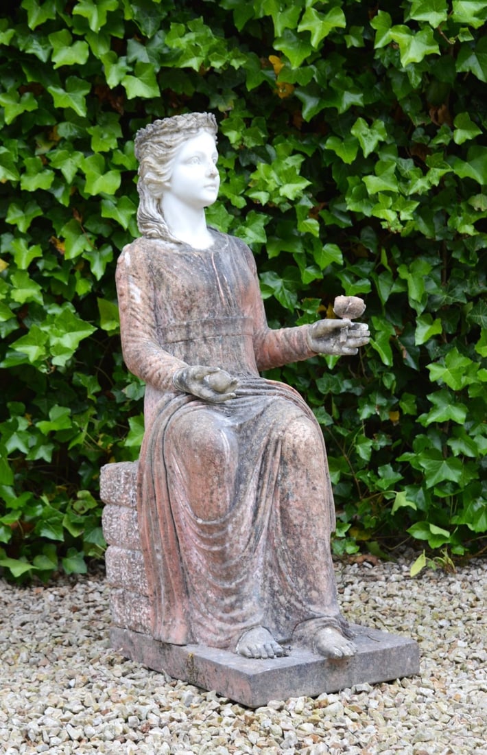 20TH-CENTURY COLOURED MARBLE SCULPTURE: OF SEATED LADY WITH FLOWER A delicately carved 20th-century coloured marble sculpture depicting a seated lady holding a flower. Executed in contrasting marbles with fine detailing and serene expressio
