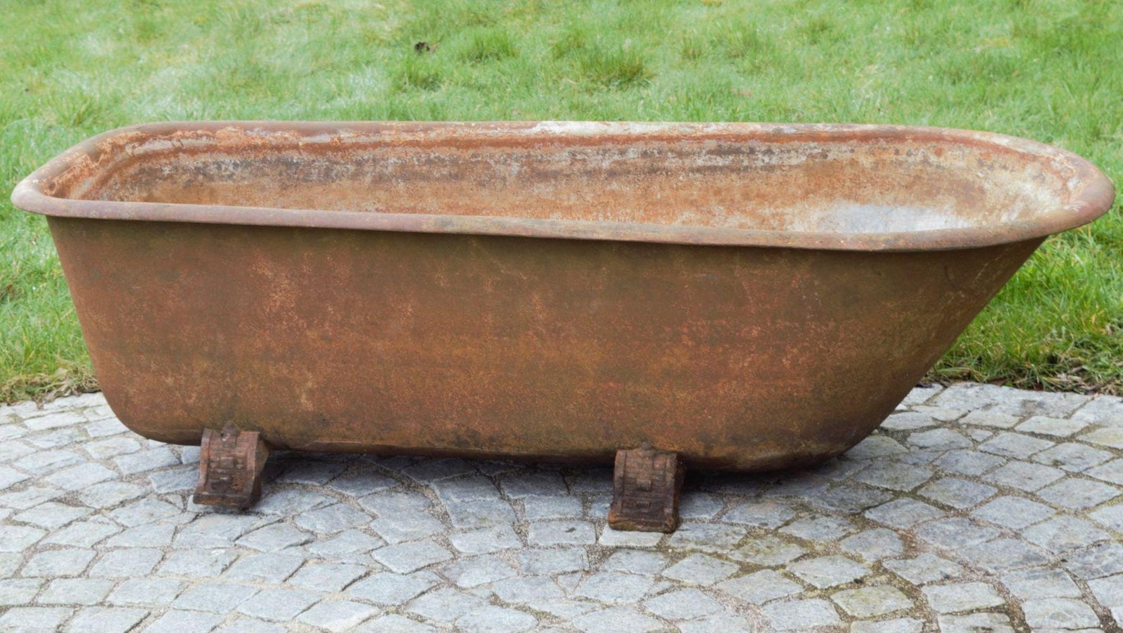 19TH-CENTURY CAST IRON BATH TUB ON SCROLL FEET: An antique cast iron bath, 19th century, with classic scroll feet and enamelled interior. Worn exterior finish.