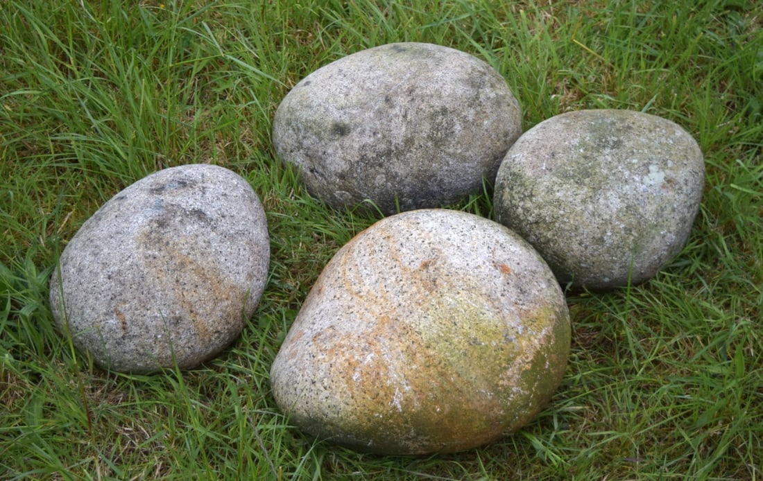 GROUP OF FOUR DECORATIVE GARDEN COASTAL ROCKS: A selection of four irregular natural stones with coastal weathering, ideal for landscaping or water features.