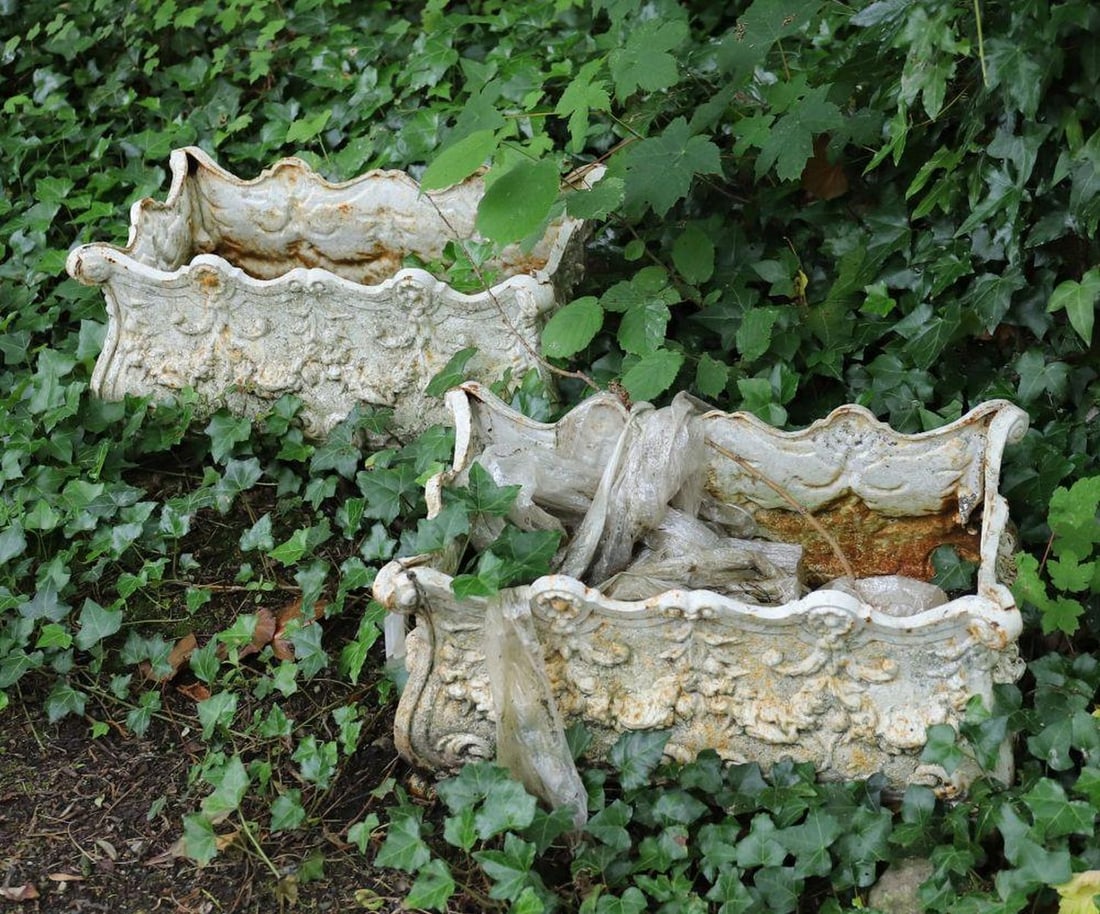 PAIR 19TH-CENTURY FRENCH CAST IRON JARDINIERES: each of rectangular bombee shape with raised leaf decoration, supported on scroll legs.