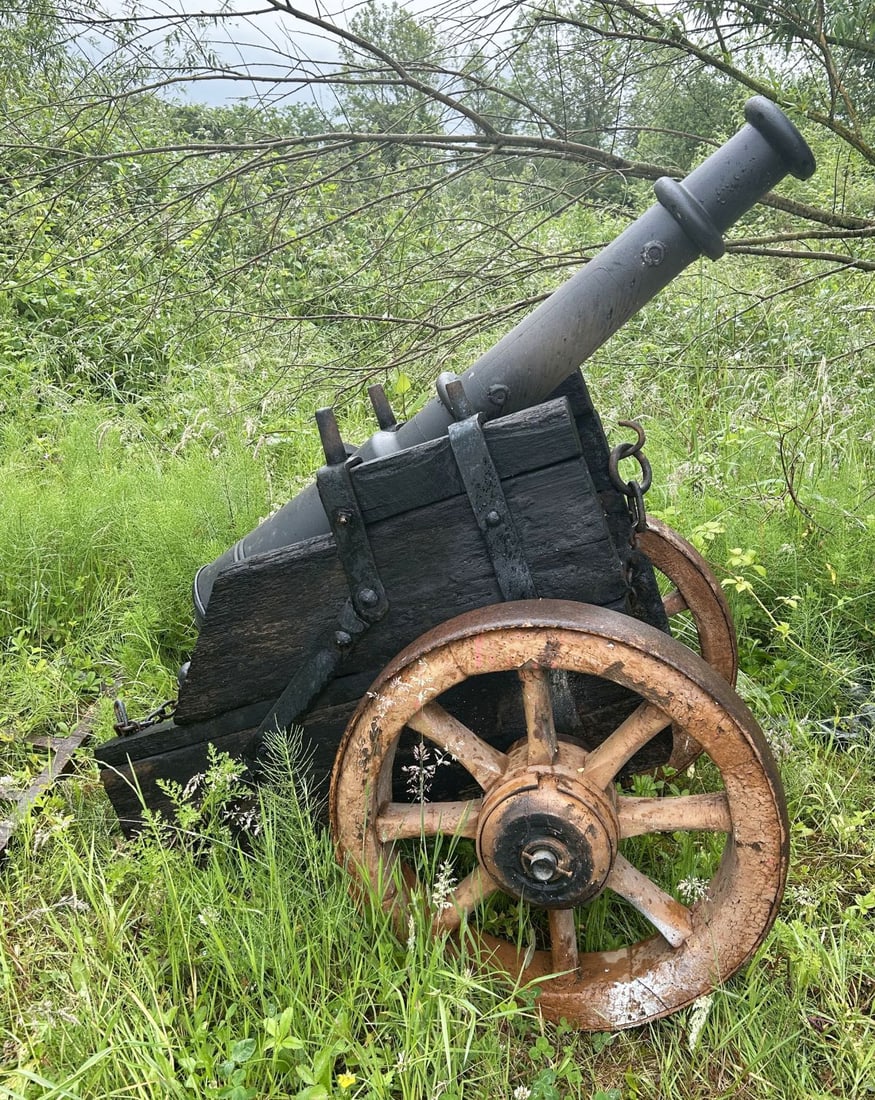 CAST IRON CANNON ON CARRIAGE: Cast iron Cannon mounted on a timber and iron-bound carriage with spoked wheels.