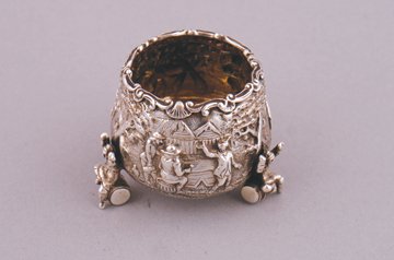 Silver salt condiment: Silver salt condiment of circular tapered form with figural decoration, raised on barrel seated figures London 1871, maker Richard Sibley