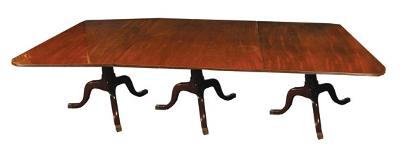 George III period mahogany four pillar dining table: George III period mahogany four pillar dining table the rectangular reeded edged top with rounded corners, raised on four scroll pillars, terminating on brass feet and castors 543 cm. long 134 cm wide