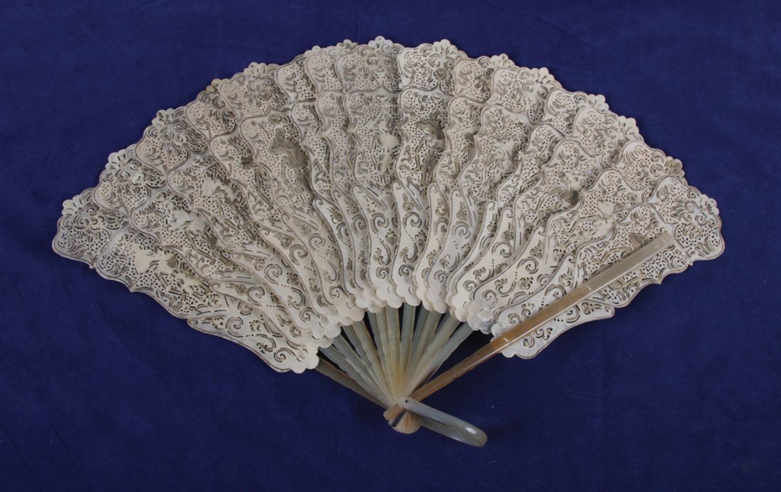 Nineteenth-century Indonesian fan leaf folding fan,: Nineteenth-century Indonesian fan leaf folding fan, circa 1850 panels of buffalo hide stamped and painted with dancers guards, sticks and ring of translucent horn 29 cm. wide