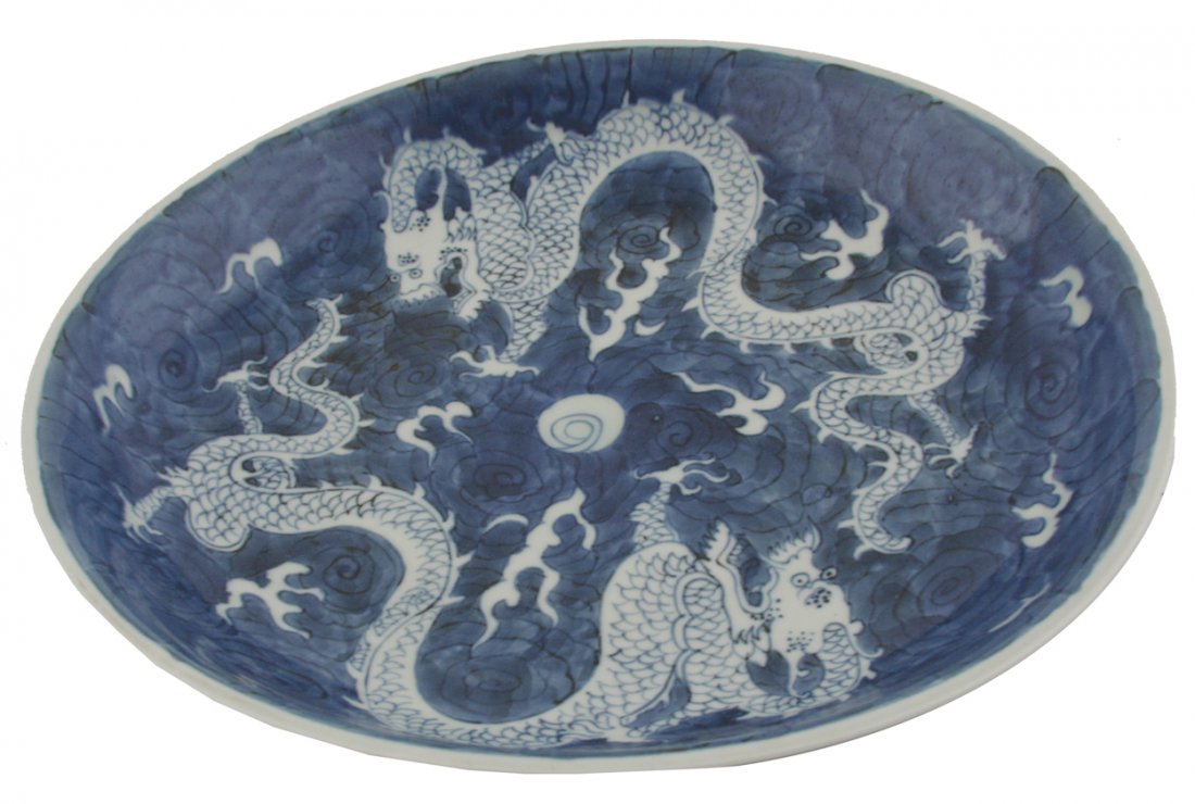 Large late-Qing period blue and white deep bowl: Large late-Qing period blue and white deep bowl decorated with dragons floating amongst clouds, mark of Kangxi 29 cm. diameter