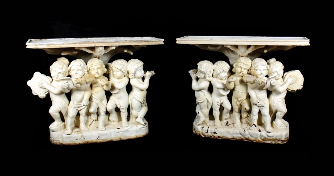 Pair of twentieth-century carved and painted mahogany: Pair of twentieth-century carved and painted mahogany cherub supported console tables each with a rectangular top, above a band of four cherub musicians, raised on a rocky mound Worldwide shipping ava