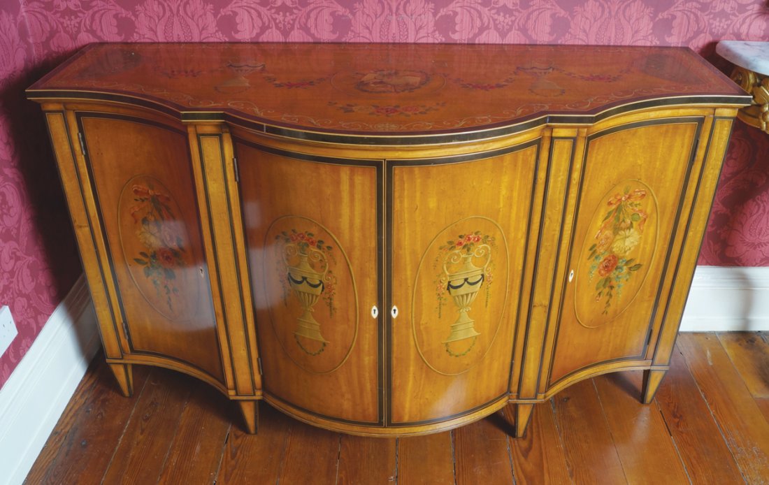 PAIR OF GEORGE III STYLE SATINWOOD PAINTED AND ROSEWOOD: PAIR OF GEORGE III STYLE SATINWOOD PAINTED AND ROSEWOOD CROSSBANDED COMMODES both in the manner of William Moore, Dublin. The top with a serpentine front, decorated with a central trophy cartouche of