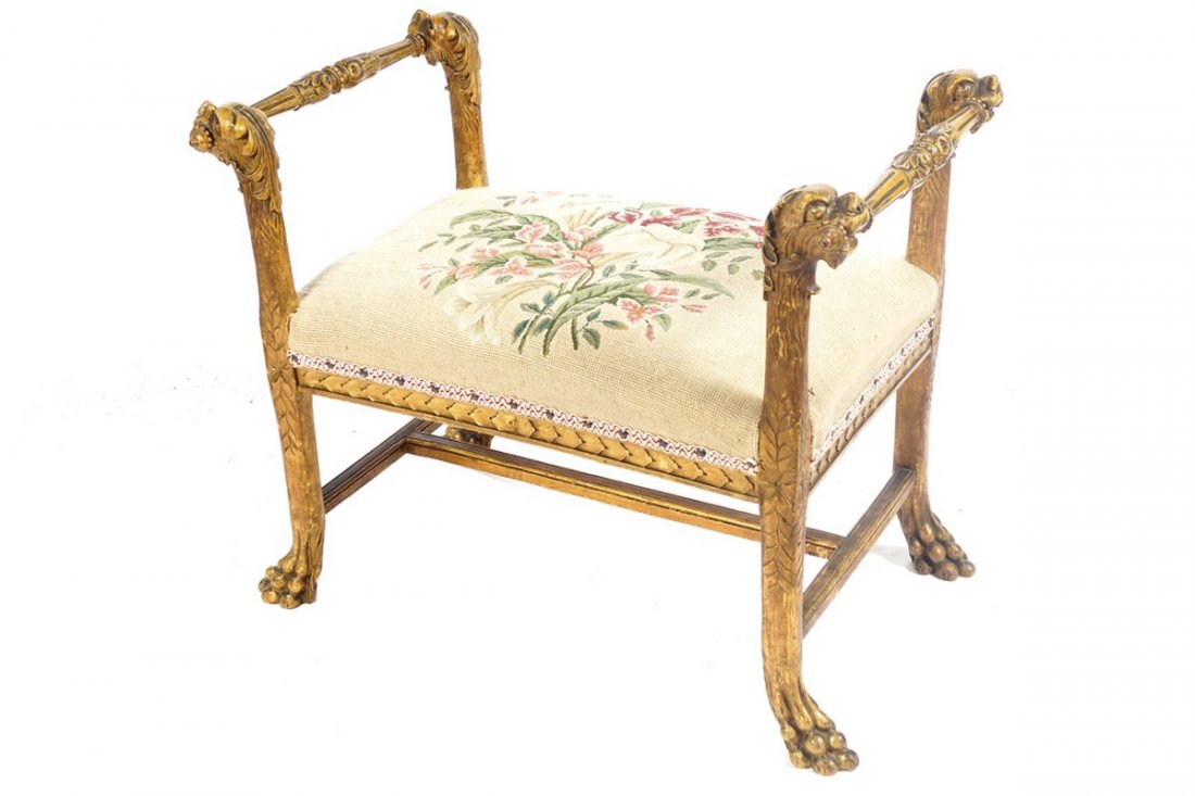 NINETEETH-CENTURY CARVED GILT WOOD WINDOW SEAT: NINETEETH-CENTURY CARVED GILT WOOD WINDOW SEAT the tapestry upholstered seat, between mask headed scroll ends, above a carved apron, raised on out-swept saber legs, joined by stretcher rails terminate
