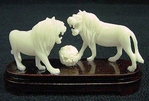 CARVED BONE LIONS SCULPTURE: HAND CARVED BONE LIONS SCULPTURE- BEAUTIFULLY DETAILED-MINT CONDITION- ROSEWOOD BASE-L 3", W 1", H2".