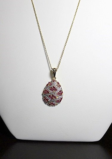 RUBY TEARDROP PENDANT: RUBY TEARDROP PENDANT - 32 RUBIES, TOTALLING 1.28CTW, SET IN STERLING SILVER WITH GOLD ACCENTS.