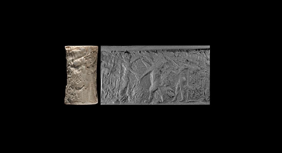 Akkadian Cylinder Seal with Hero Scene: 23rd-22nd century BC. A carved fossil shell cylinder seal with scene of combat and inscription; accompanied by a museum-quality impression and an old scholarly note, typed and signed by W.G. Lambert, 