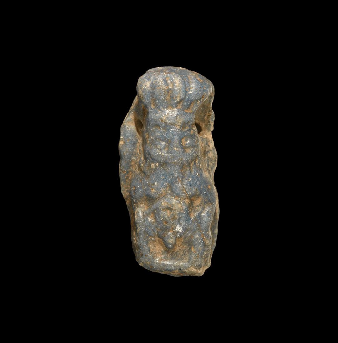 Egyptian Bes Amulet: Late Period, 664-332 BC. A deep blue glazed composition D-section figure of Bes in feathered headdress. Cf. Andrews, C. Amulets of Ancient Egypt, London, 1994, item 37(a) for type. 7.11 grams, 34mm (1