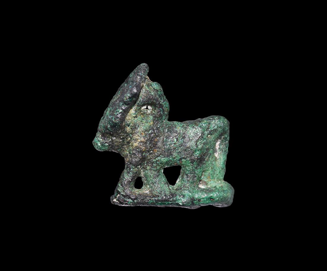 Egyptian Apis Bull Amulet: Late Period, 664-332 BC. A bronze amuletic figurine of the Apis Bull, advancing on a base, with sun-disc between the horns. Cf. Andrews, C. Amulets of Ancient Egypt, London, 1994, item 21(b"). 2.89 gr