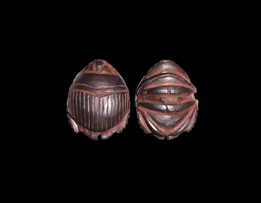 Egyptian Heart Scarab: Late Period, 664-332 BC. A hematite amulet in the form of a heart scarab with detailing of the head, abdomen, wing case and legs curled to the underside of the body. 5.58 grams, 19mm (1 3/4"). Propert