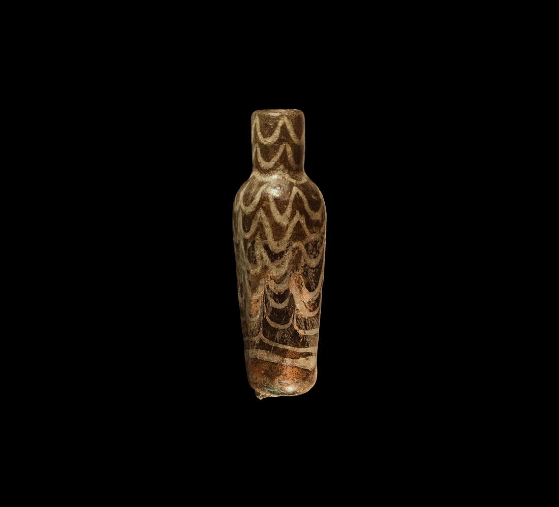 Islamic Fatimid Marbled Glass Vessel: 10th-12th century AD. A hexagonal-section brown glass bottle with dragged trail detailing, tubular neck. 29 grams, 74mm (3"). Acquired on the London art market before 2000.