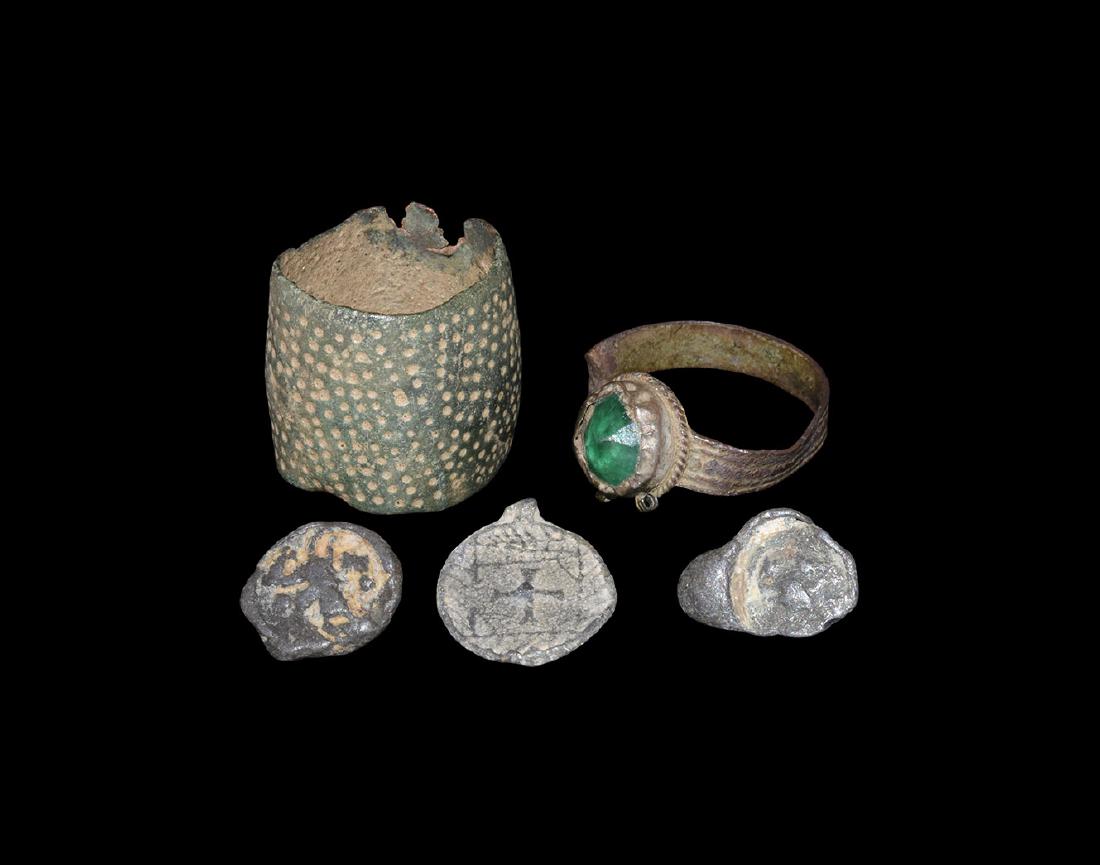Byzantine Ring and Other Items Group: 10th-14th century AD. A mixed bronze group comprising: an annular thimble with indented surface; a finger ring with green glass cabochon to the bezel; a bifacial pendant; two cast tokens(?). 20 grams 