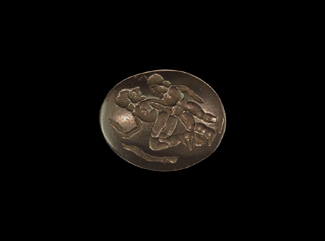 Bactrian Intaglio with Standing Figures: 2nd millennium BC. A plano-convex glass plaque with figures, one standing with head in profile facing the second with bent knees and feather or frond in his hand. 7.84 grams, 28mm (1"). Property of a 