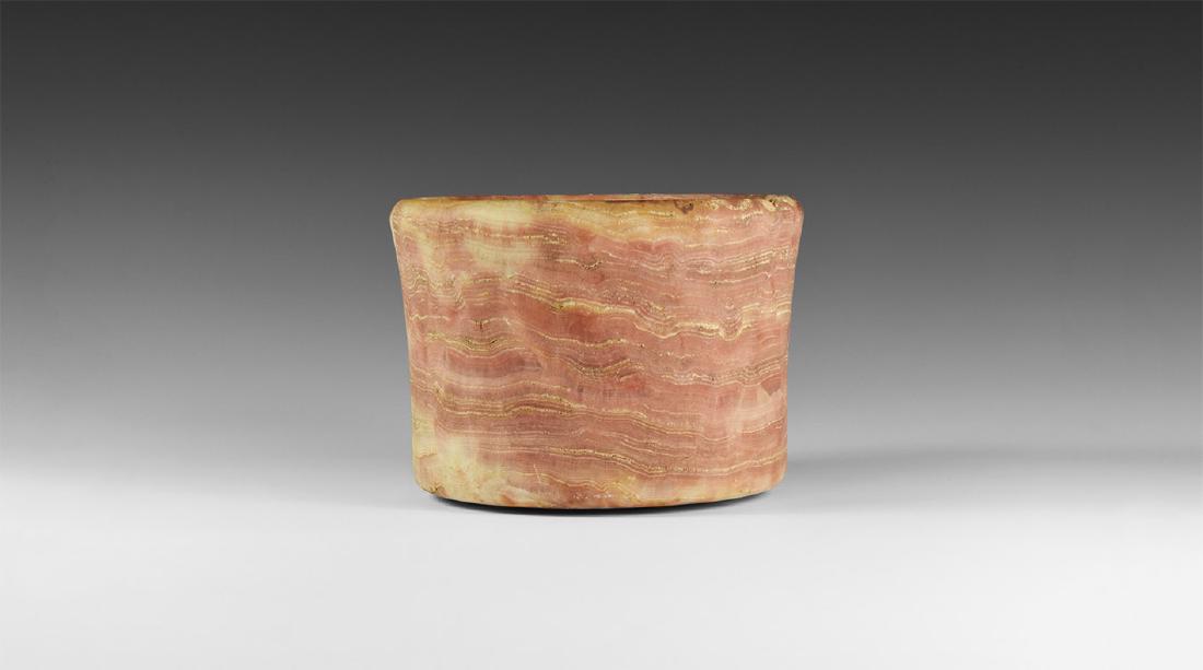 Mesopotamian Veined Pink Jar: 3rd-2nd millennium BC. A broad alabaster squat jar with with slightly flaring sides and chamfered rim, polychrome appearance from red to cream. 1.2 kg, 13.5cm (5 1/4"). Ex Terence Eva collection, form