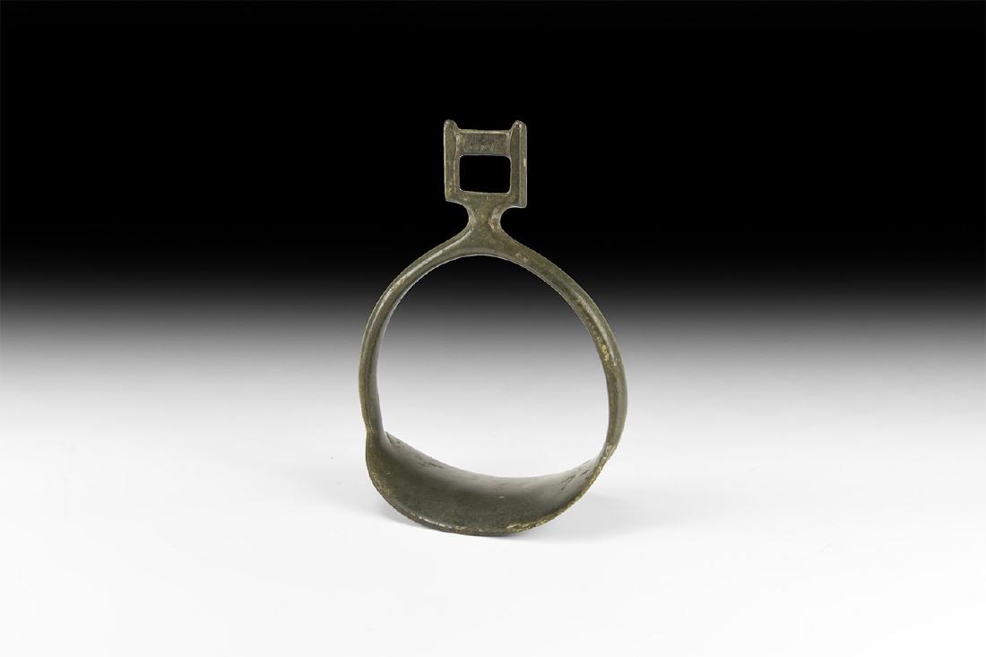Viking Horseman's Stirrup: 8th-10th century AD. A bronze stirrup with ribbed footplate, arched body, square bracket with slot to accept the strap. Cf. Arbman, H. Birka I: Die Gräber, Uppsala, 1940, grave 735. 248 grams, 14cm (