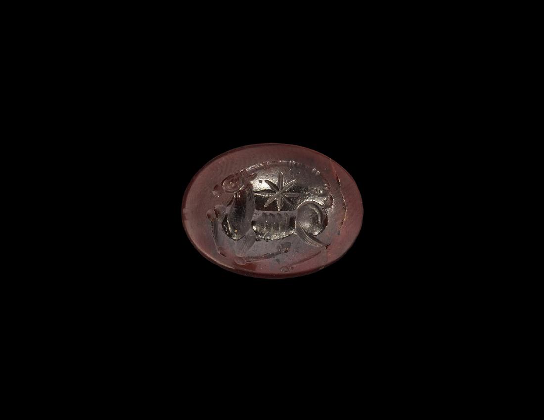 Sassanian Intaglio with Reclining Ibex: 3rd-7th century AD. A garnet intaglio engraved with a reclining ibex, long horns curving back and with star between horns and body. 2.78 grams, 20mm (3/4"). From a large London collection; formed betw