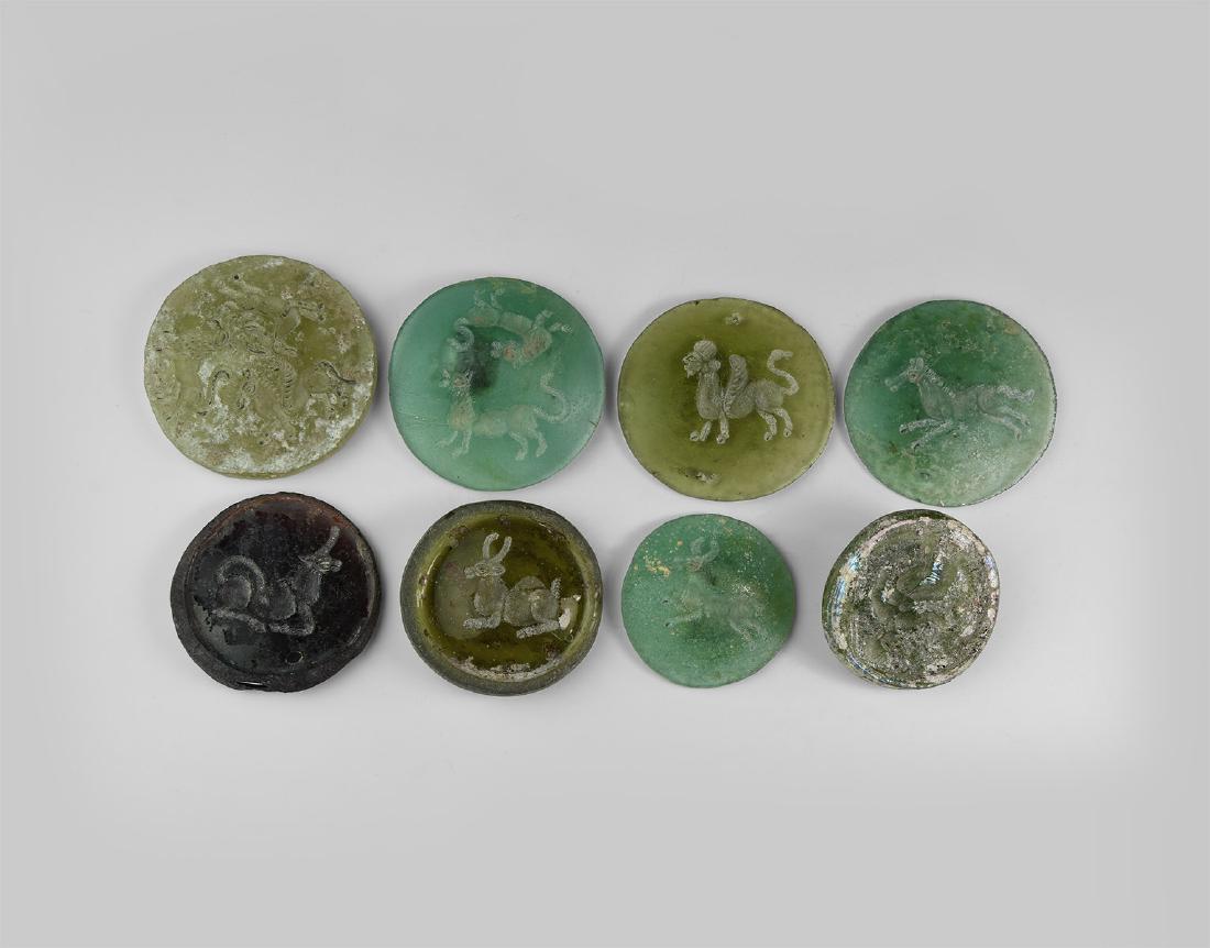 Western Asiatic Style Engraved Glass Roundels: An undated archaistic group of aqua and other glass discs, each slightly domed and with a zoomorphic motif. 265 grams total, 41-59mm (1 3/4 - 2 1/2"). Property of a London gentleman; acquired before 2