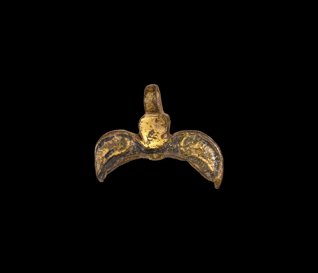Norman Gilt Horse Harness Pendant: 11th-12th century AD. A gilt-bronze pendant comprising a lobe with flanking wings, blue enamel fill with reserved detailing, pierced lug above. 6.96 grams, 35mm (1 1/2"). Found near Market Rasen, Linc