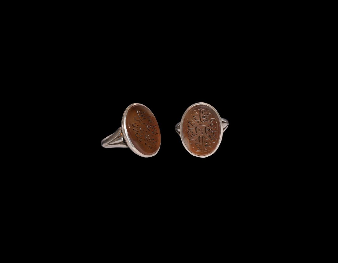 Islamic Silver Ring with Calligraphic Gemstone: 19th-early 20th century AD. A silver ring comprising a D-section hoop with trefoil shoulders, ellipsoid bezel with running zigzag pattern to the underside, inset carnelian cloison with incised quatref