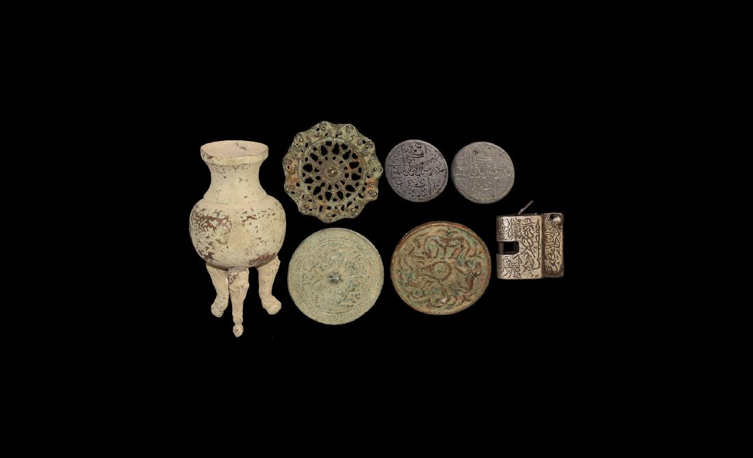 Islamic Artefact Group: An undated archaistic group of bronze items including two Chinese style disc mirrors, an openwork plaque with monkeys to the rim, a padlock with key. two discs with calligraphic text, a tripod vessel 